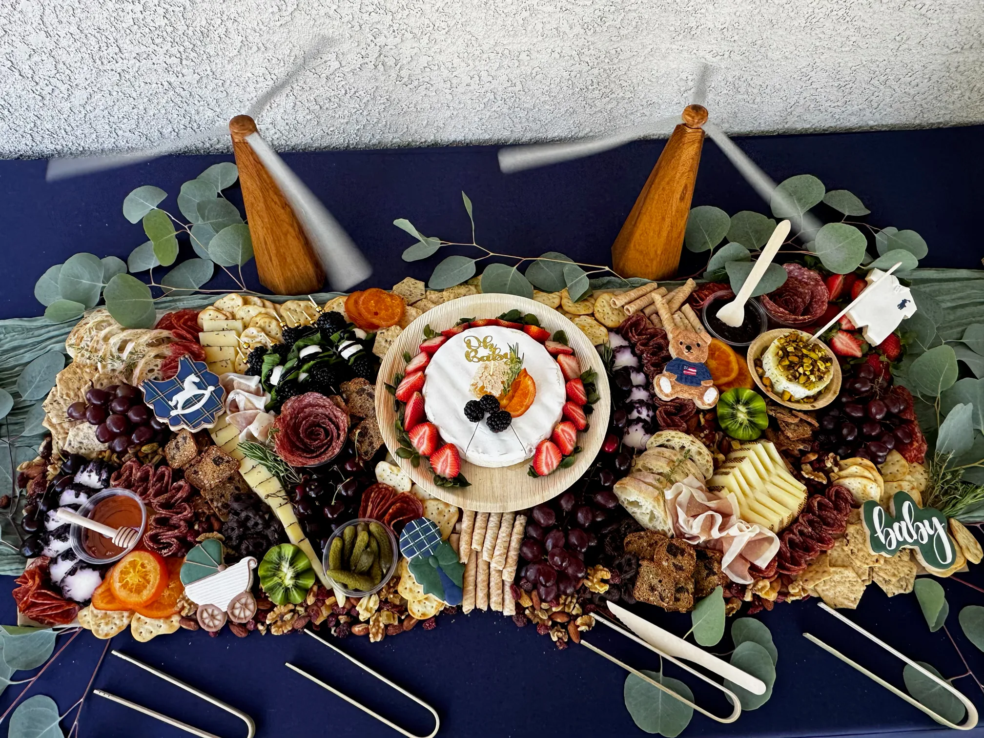 Baby shower charcuterie spread with a brie centerpiece, berries and decorated cookies