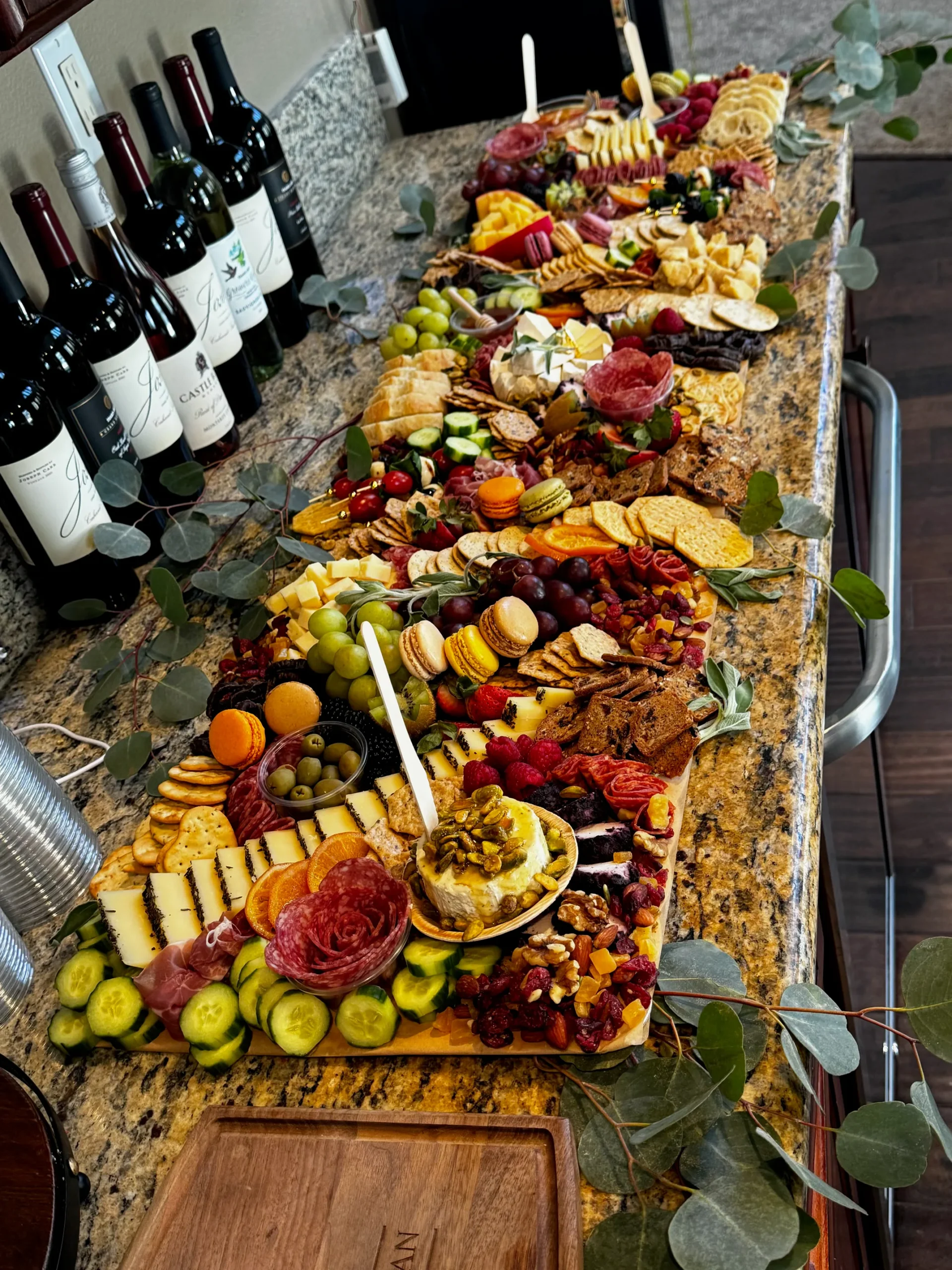 Charcuterie spread with salami roses, cheeses, fruit, crackers and macarons